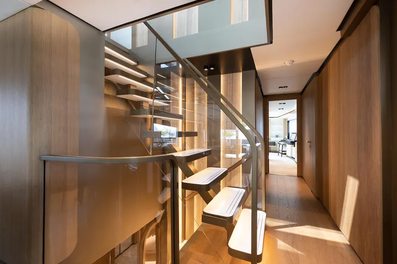 Slide: The Image of Modern interior staircase on a 2026 Majesty 111 yacht, featuring sleek wood and glass design. - 25
