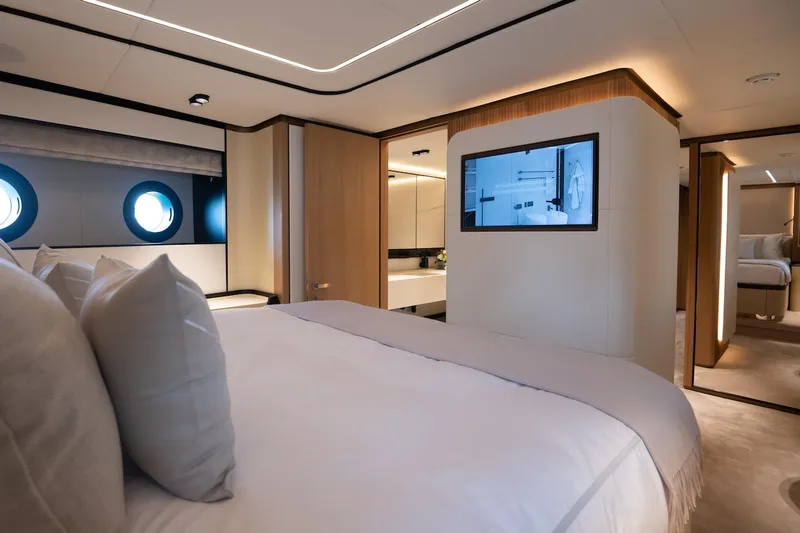 Slide: The Image of Luxurious bedroom interior on 2026 Majesty 111 yacht, featuring modern design and porthole windows. - 38