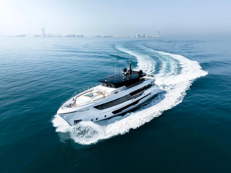 Slide: The Image of Luxurious 2026 Majesty 111 yacht cruising on open sea with city skyline backdrop. - 4