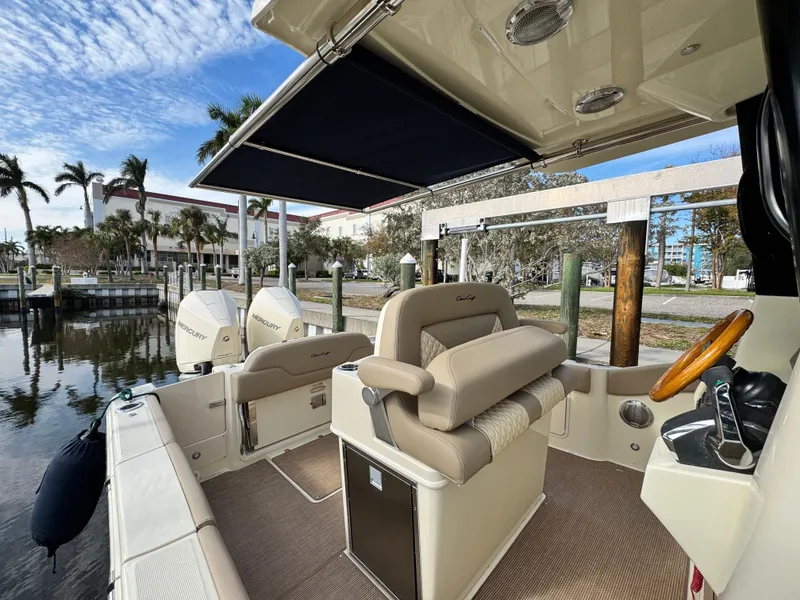 Slide: The Image of 2025 Chris-Craft Catalina 28 boat interior with helm, seating, and dual engines at dock. - 14