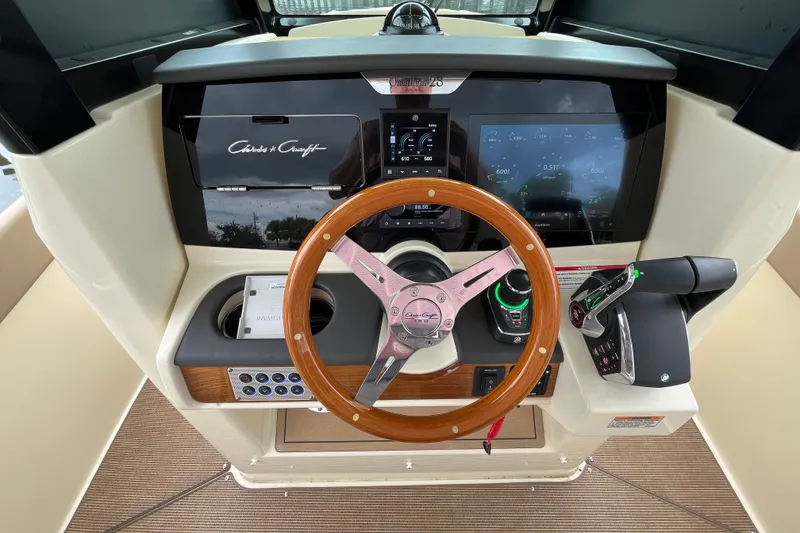 Slide: The Image of 2025 Chris-Craft Catalina 28 helm with wooden steering wheel and modern controls. - 19