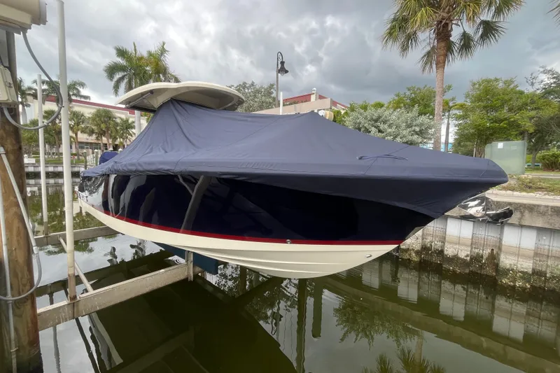 Slide: The Image of 2025 Chris-Craft Catalina 28 boat covered, docked near palm trees and water. - 38