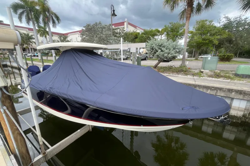 Slide: The Image of 2025 Chris-Craft Catalina 28 boat covered, docked near palm trees and buildings. - 39