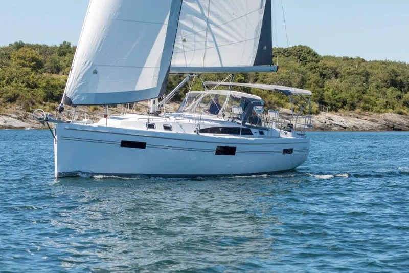 Slide: The Image of 2025 Catalina 426 sailboat cruising on a serene lake with lush green shoreline. - 9