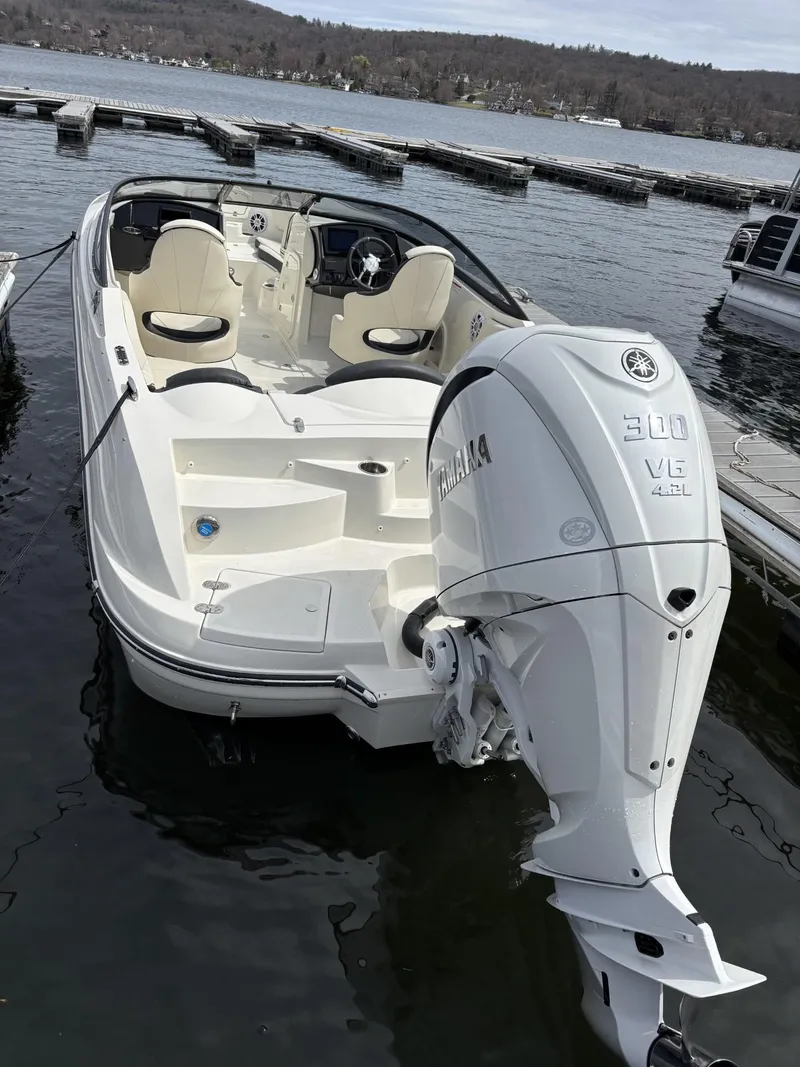 Slide: The Image of 2024 Stingray 23 OSX boat with Yamaha 300 engine docked on a lake. - 2