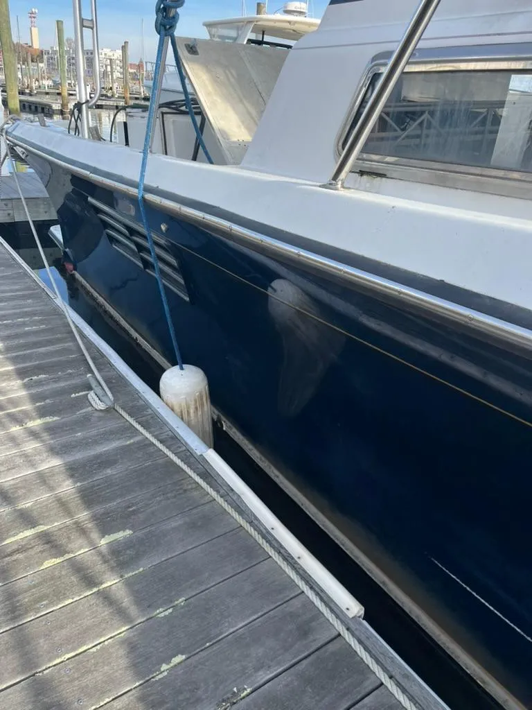 Slide: The Image of 2005 Albin 45 Command Bridge docked, side view with blue hull and white deck. - 17