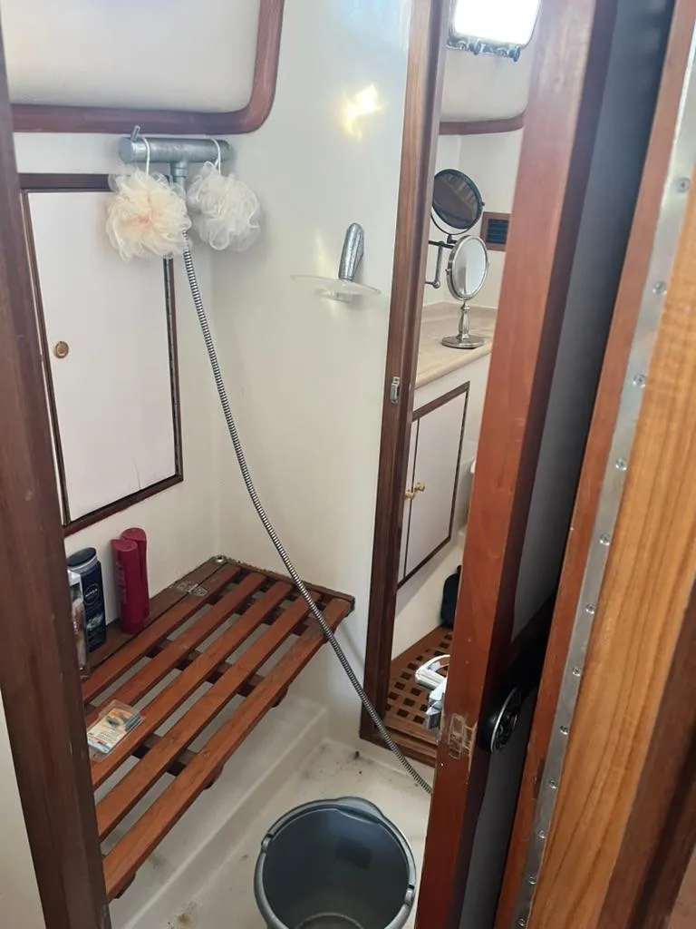 Slide: The Image of 2005 Albin 45 Command Bridge bathroom with shower, wooden accents, and toiletries. - 18