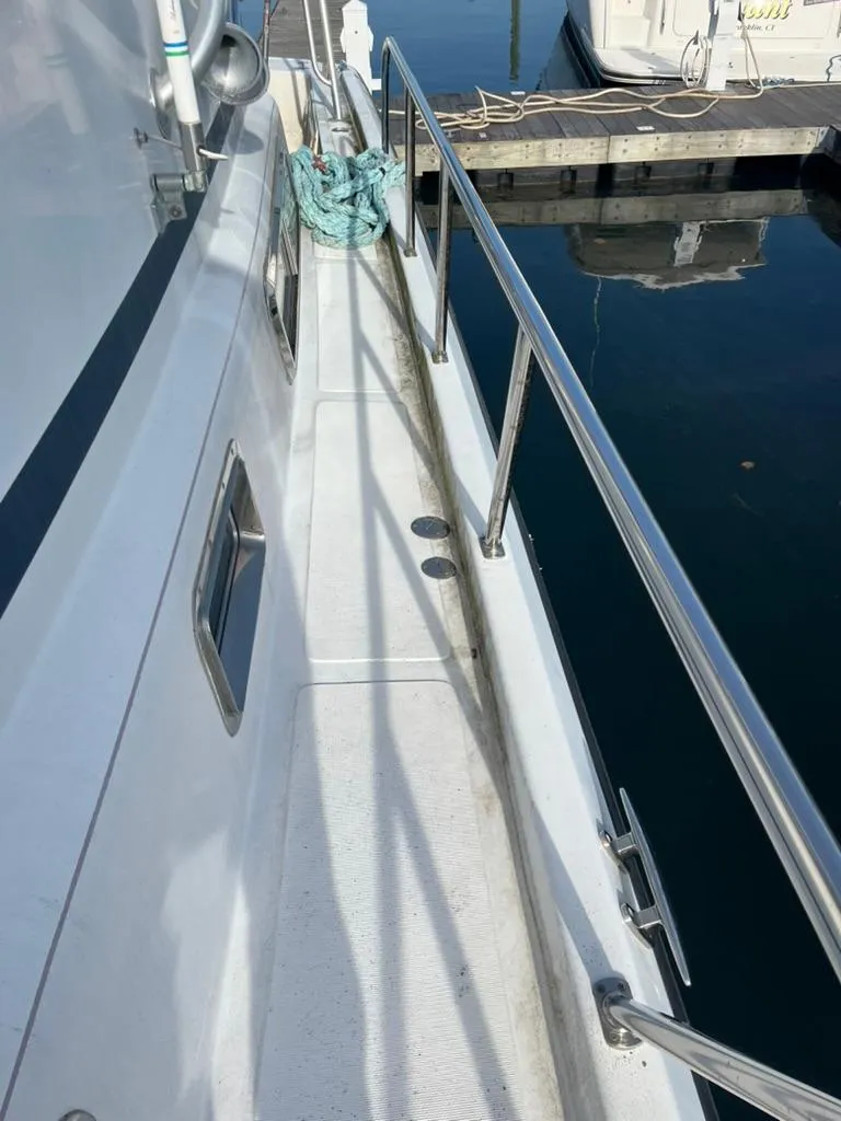 Slide: The Image of 2005 Albin 45 Command Bridge yacht docked, showing side deck and railing. - 21