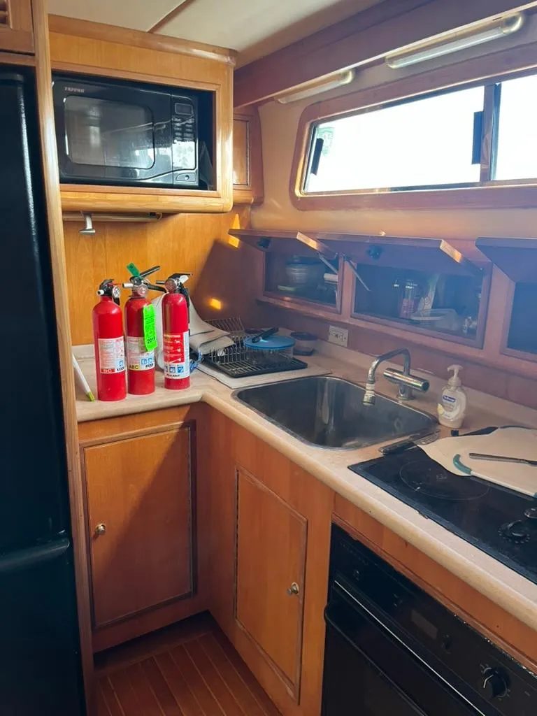 Slide: The Image of 2005 Albin 45 Command Bridge kitchen with fire extinguishers, microwave, and sink. - 6
