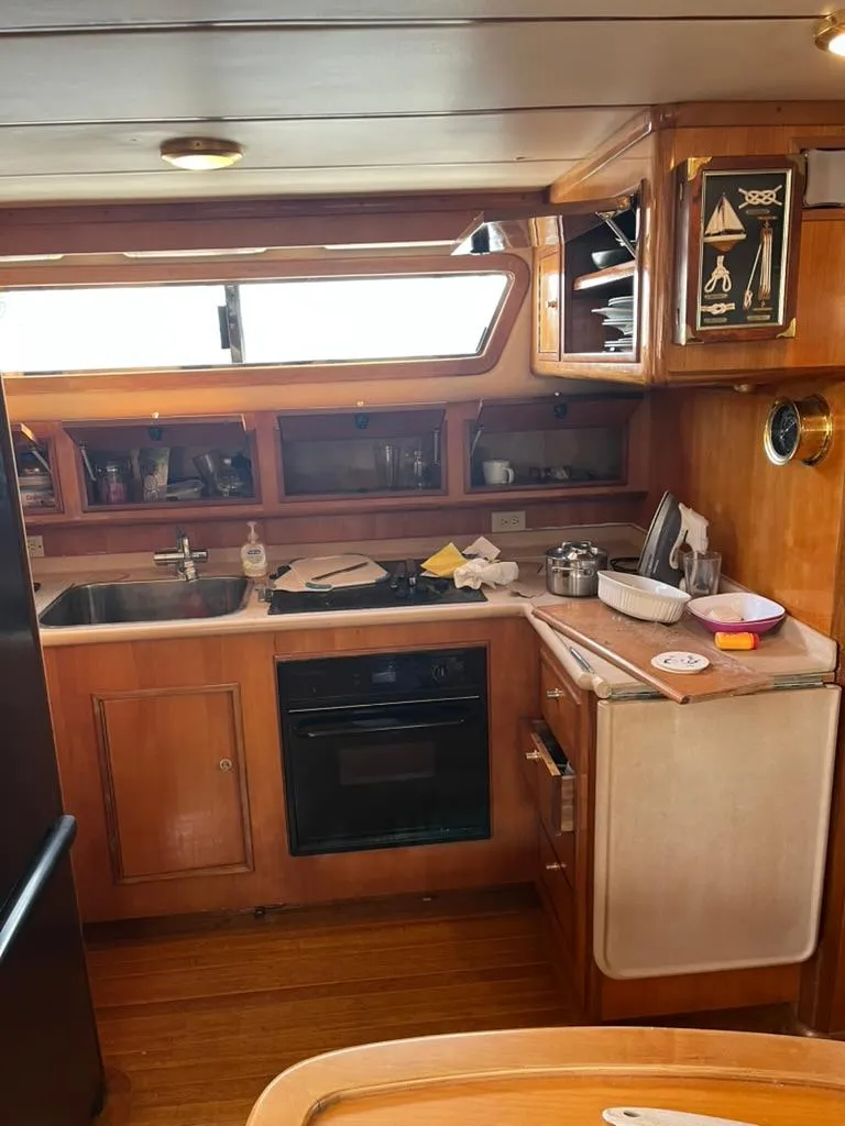Slide: The Image of 2005 Albin 45 Command Bridge kitchen with wooden cabinetry and modern appliances. - 7