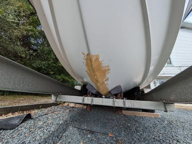 Slide: The Image of 1999 Hydra-Sports 2450 CCH boat hull with visible damage on trailer. - 24