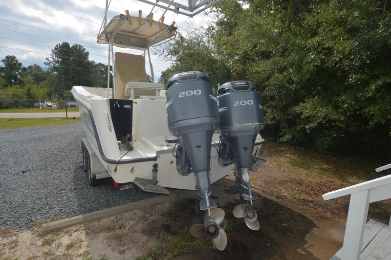 Slide: The Image of 1999 Hydra-Sports 2450 CCH boat with dual 200 horsepower outboard motors, parked on gravel. - 4