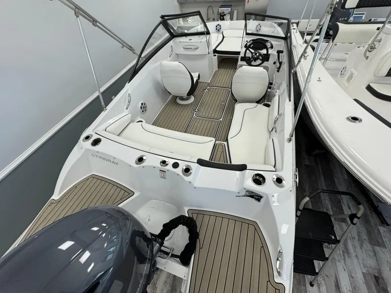 The Image of 2025 Stingray 191 DC boat interior with white seating and wood accents. - 1