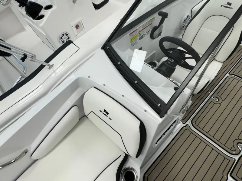 Slide: The Image of 2025 Stingray 191 DC boat interior with white seating and modern dashboard. - 10