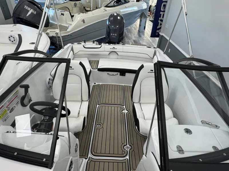Slide: The Image of 2025 Stingray 191 DC boat interior with white seating and wood-style flooring. - 11