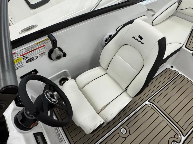Slide: The Image of 2025 Stingray 191 DC boat interior with white seating and steering wheel. - 12