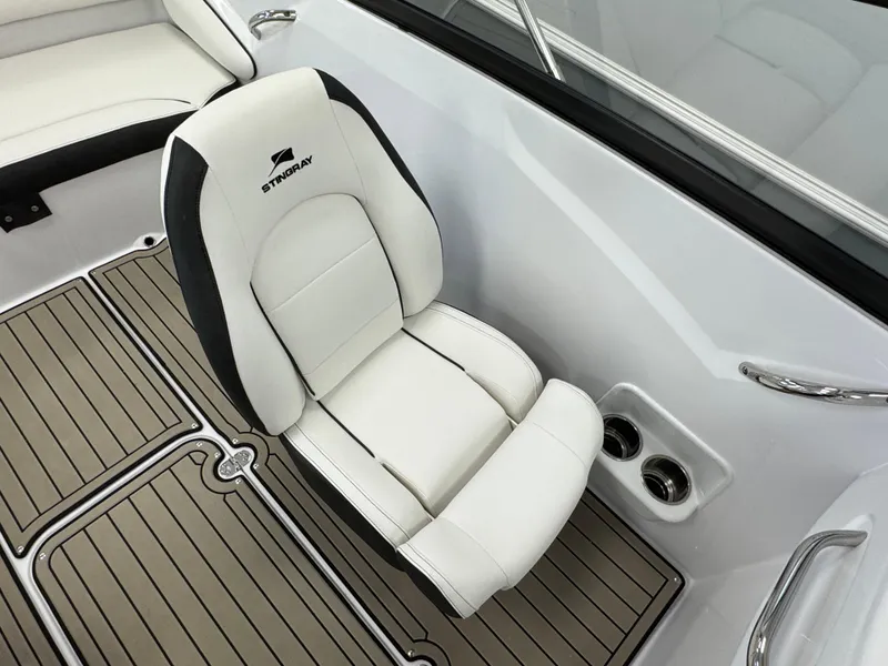 Slide: The Image of 2025 Stingray 191 DC boat interior with white cushioned seat and wood-patterned flooring. - 13