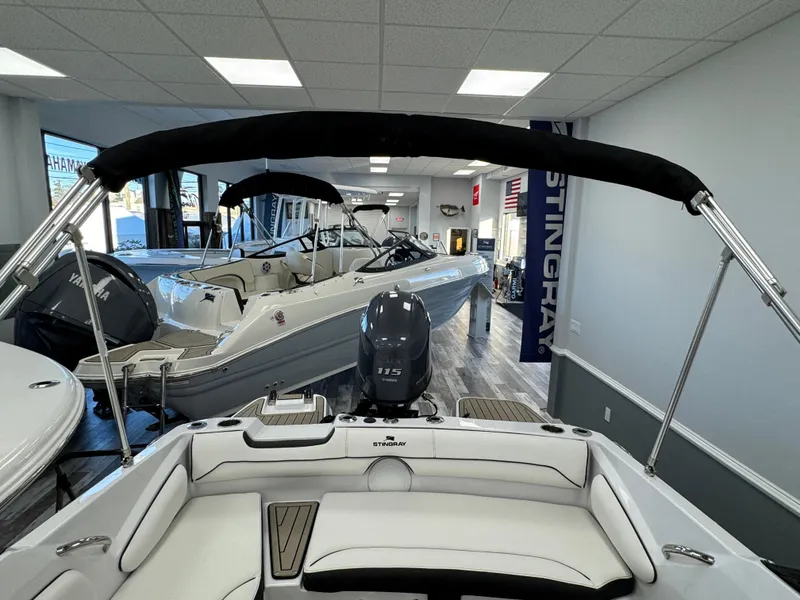 Slide: The Image of 2025 Stingray 191 DC boat displayed in showroom with sleek interior design. - 16