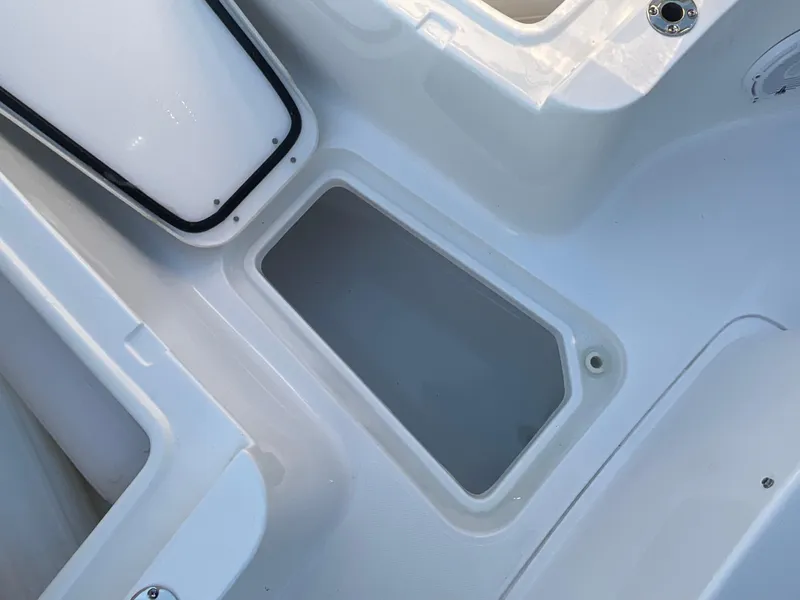 Slide: The Image of 2024 Sea Hunt Ultra 265 SE boat storage compartment, white interior. - 12
