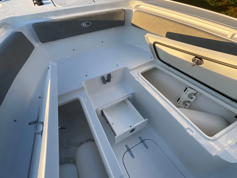 Slide: The Image of 2024 Sea Hunt Ultra 265 SE boat interior with storage compartments and seating. - 13