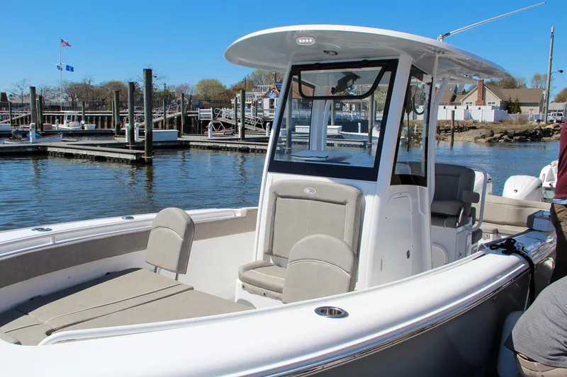 Slide: The Image of 2024 Sea Hunt Ultra 265 SE boat docked at marina, featuring spacious seating and sleek design. - 2