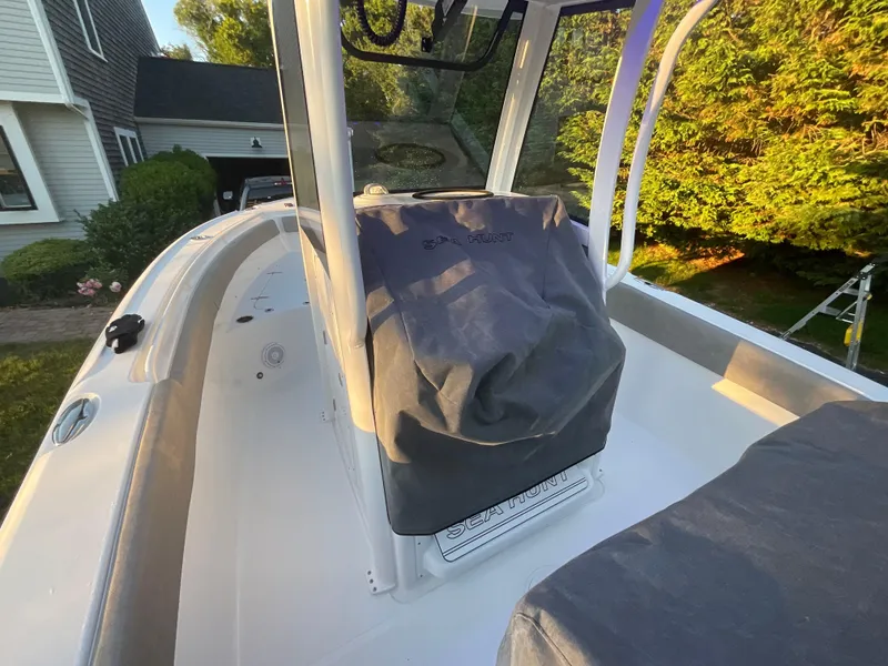 Slide: The Image of 2024 Sea Hunt Ultra 265 SE boat interior with covered console in sunlight. - 24