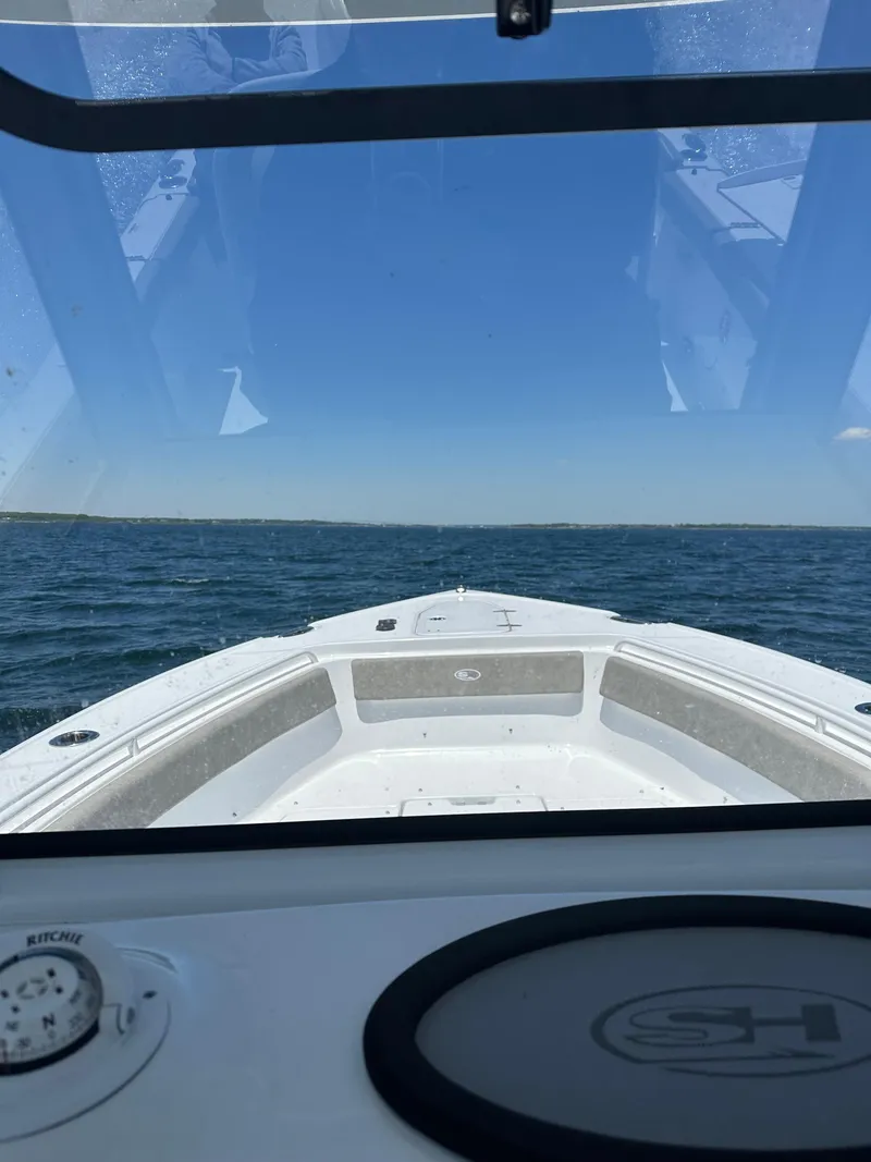 Slide: The Image of 2024 Sea Hunt Ultra 265 SE boat on open water, viewed from the helm. - 26