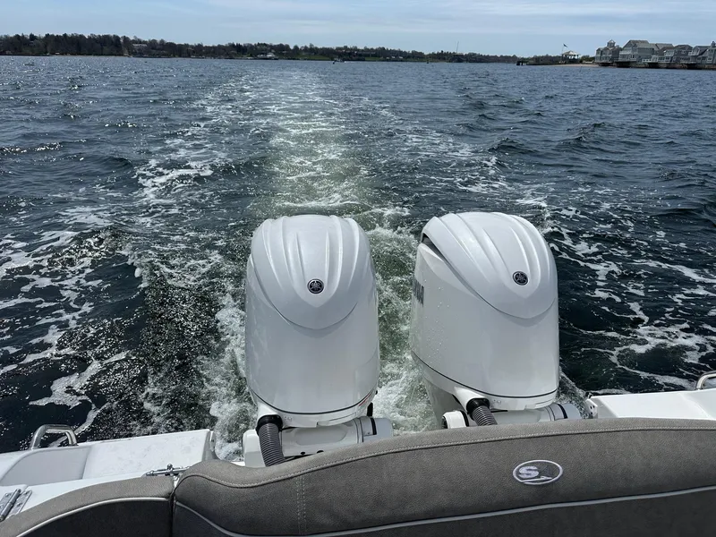 Slide: The Image of 2024 Sea Hunt Ultra 265 SE boat with dual engines cruising on open water. - 3