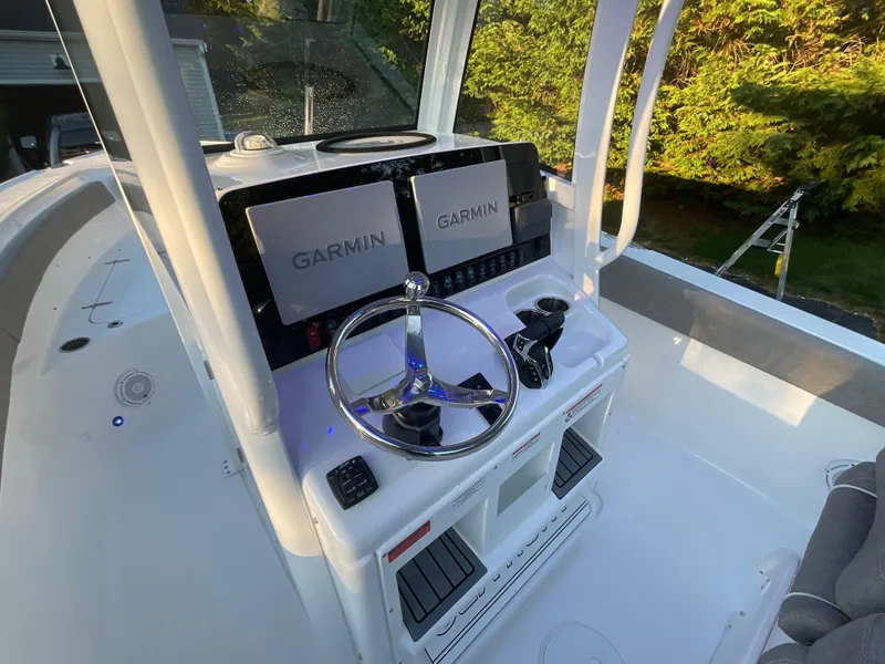 Slide: The Image of 2024 Sea Hunt Ultra 265 SE boat dashboard with Garmin displays and steering wheel. - 6