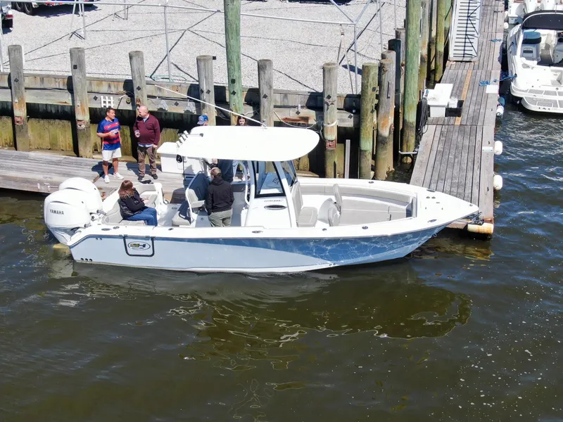 Slide: The Image of 2024 Sea Hunt Ultra 265 SE boat docked with people onboard. - 8