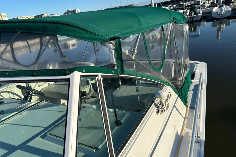 Slide: The Image of 2001 Mainship Pilot 30 boat with green canopy docked at marina. - 11