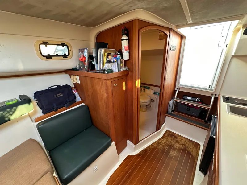 Slide: The Image of 2001 Mainship Pilot 30 cabin interior with wood paneling and seating area. - 19