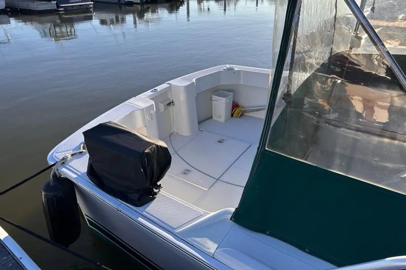 Slide: The Image of 2001 Mainship Pilot 30 boat docked, featuring spacious deck and protective cover. - 2