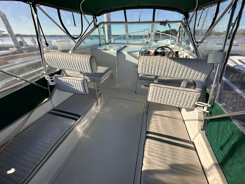 Slide: The Image of 2001 Mainship Pilot 30 boat interior with cushioned seating and steering area. - 3