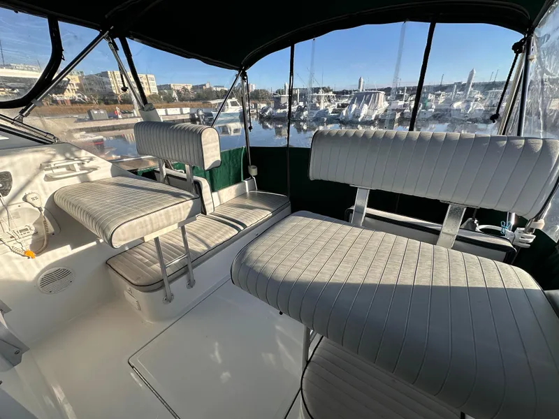 Slide: The Image of 2001 Mainship Pilot 30 interior with cushioned seating, overlooking marina through large windows. - 4