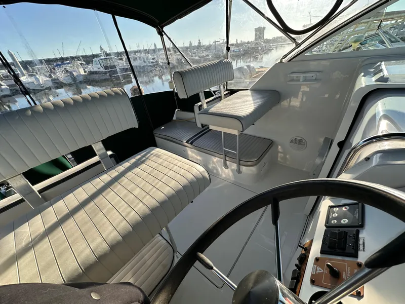 Slide: The Image of 2001 Mainship Pilot 30 boat interior with seating and helm, docked at marina. - 5