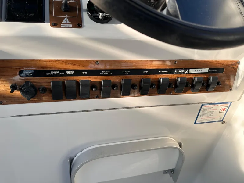 Slide: The Image of Control panel of a 2001 Mainship Pilot 30 boat with switches and wooden trim. - 8