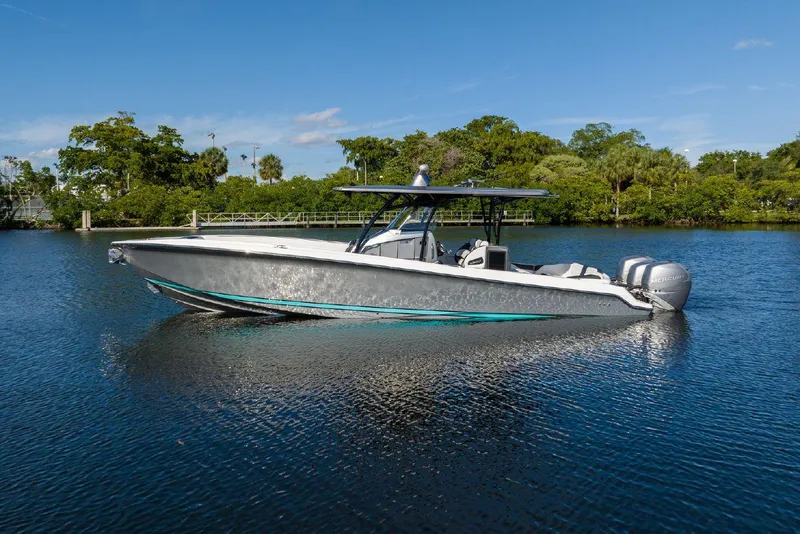 Slide: The Image of 2023 Nor-Tech 340 Sport Center Console boat on a serene lake. - 0
