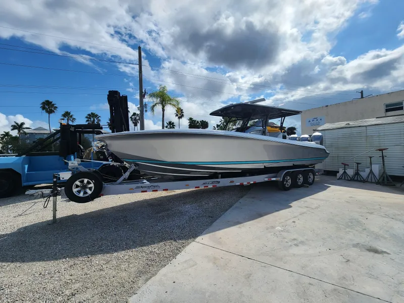 Slide: The Image of 2023 Nor-Tech 340 Sport Center Console boat on trailer, parked outdoors under cloudy sky. - 1