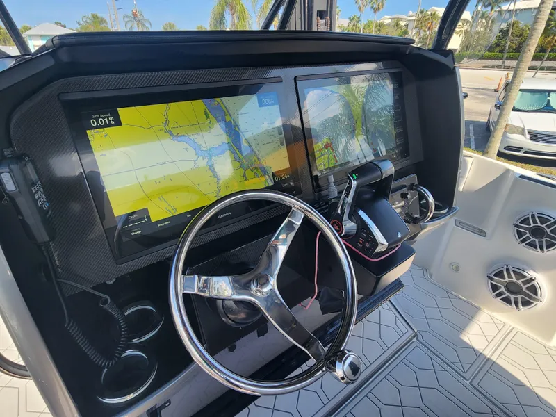 Slide: The Image of 2023 Nor-Tech 340 Sport Center Console helm with dual navigation screens and steering wheel. - 17