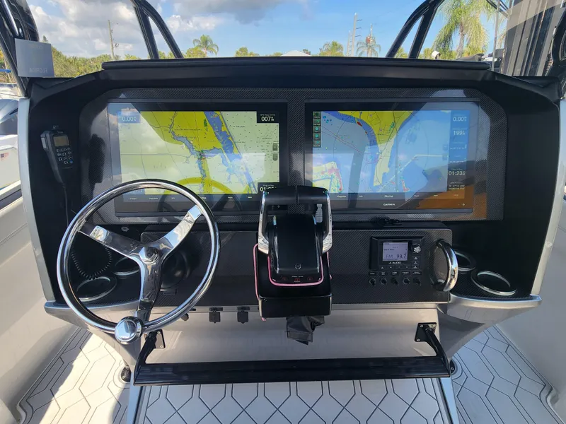 Slide: The Image of 2023 Nor-Tech 340 Sport Center Console dashboard with dual navigation screens and steering wheel. - 18