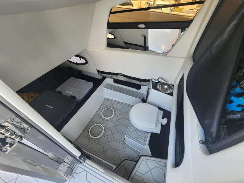 Slide: The Image of 2023 Nor-Tech 340 Sport Center Console cabin interior with toilet and storage compartments. - 19