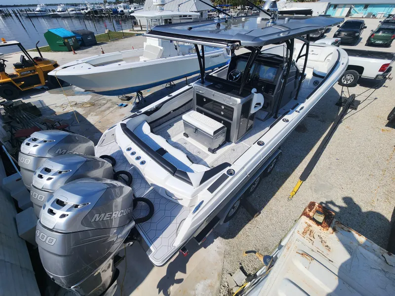 Slide: The Image of 2023 Nor-Tech 340 Sport Center Console boat with triple Mercury engines docked at marina. - 4