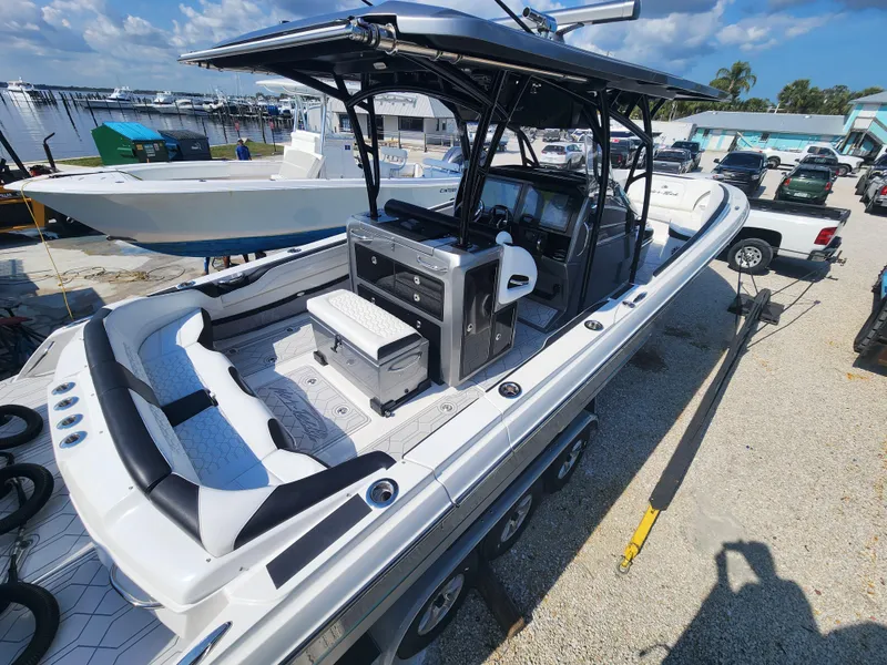 Slide: The Image of 2023 Nor-Tech 340 Sport Center Console boat at marina, featuring sleek design and spacious seating. - 5