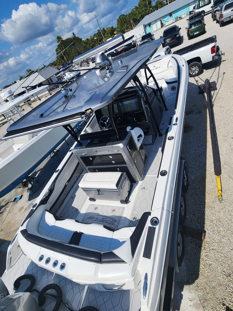 Slide: The Image of 2023 Nor-Tech 340 Sport Center Console boat with sleek design, docked under a clear sky. - 6