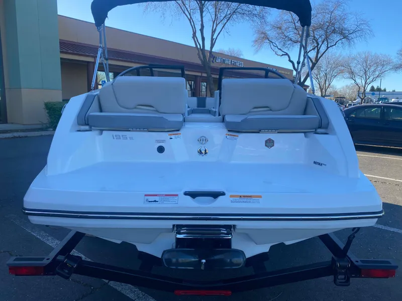 Slide: The Image of 2025 Scarab 195 SE boat, rear view in parking lot, showcasing seating and design. - 22
