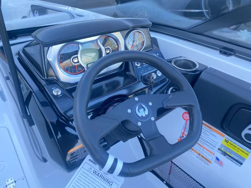 Slide: The Image of 2025 Scarab 215 SE boat dashboard with steering wheel and gauges. - 13