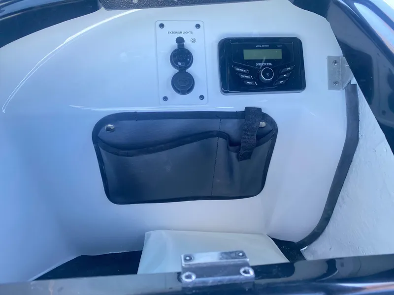 Slide: The Image of 2025 Scarab 215 SE boat dashboard with controls and storage pocket. - 16