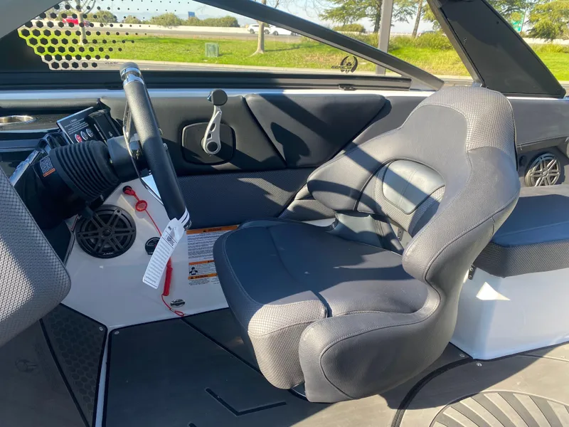 Slide: The Image of Interior of 2025 Scarab 235 LX Wake boat, featuring a sleek driver's seat and modern dashboard. - 12