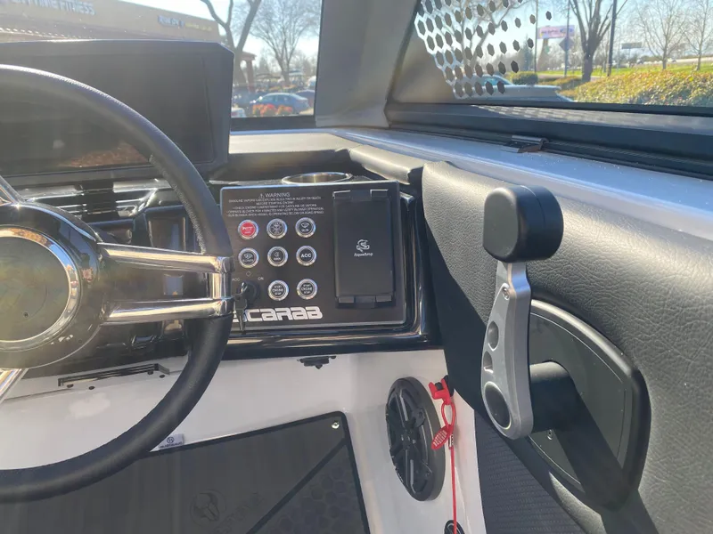 Slide: The Image of 2025 Scarab 235 LX Wake boat dashboard with steering wheel and control panel. - 14